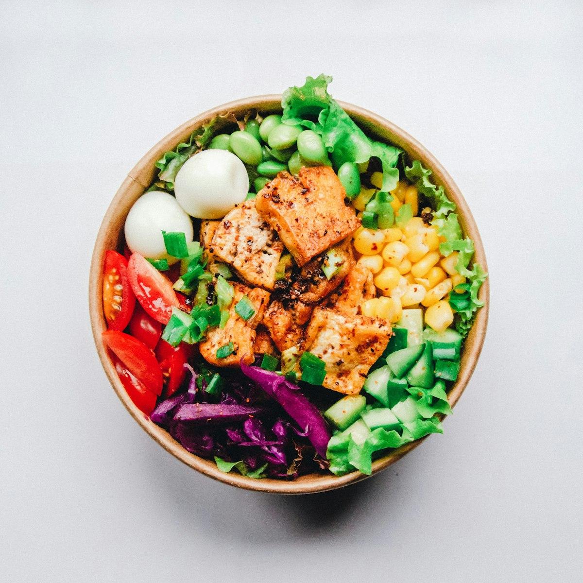 Colorful healthy meal with fresh vegetables and grains in a white bowl